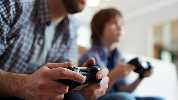 Zwei Menschen, die Gamecontroller in den Händen halten.