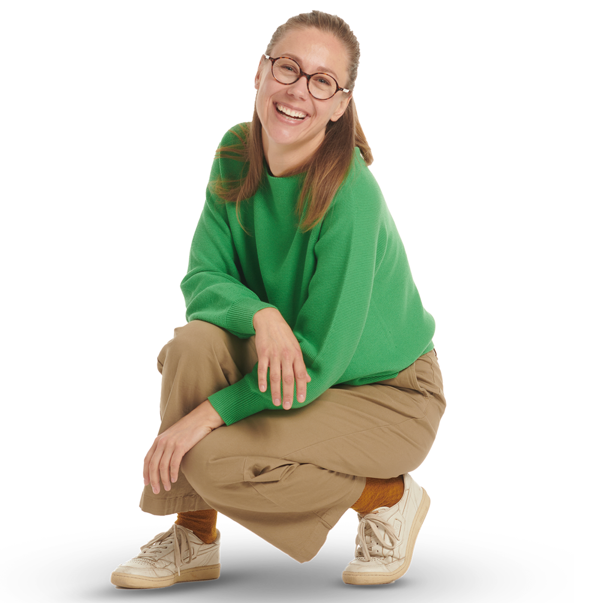 Eine junge Frau mit Brille in einem grünen Pullover in sitzender Haltung.