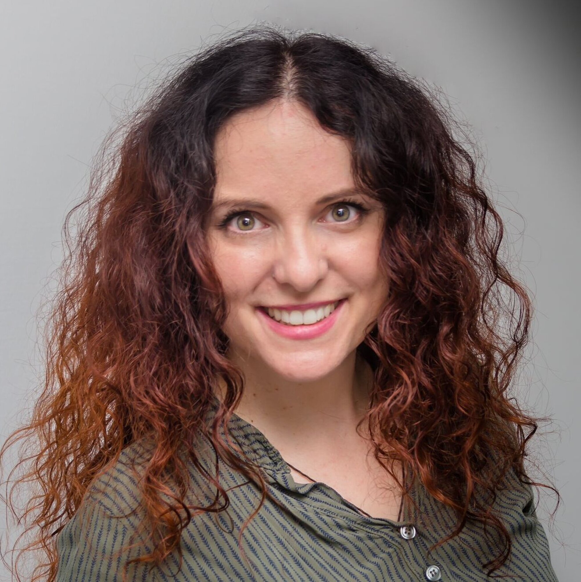 Bild einer jungen Frau mit schwarz-roten Locken.