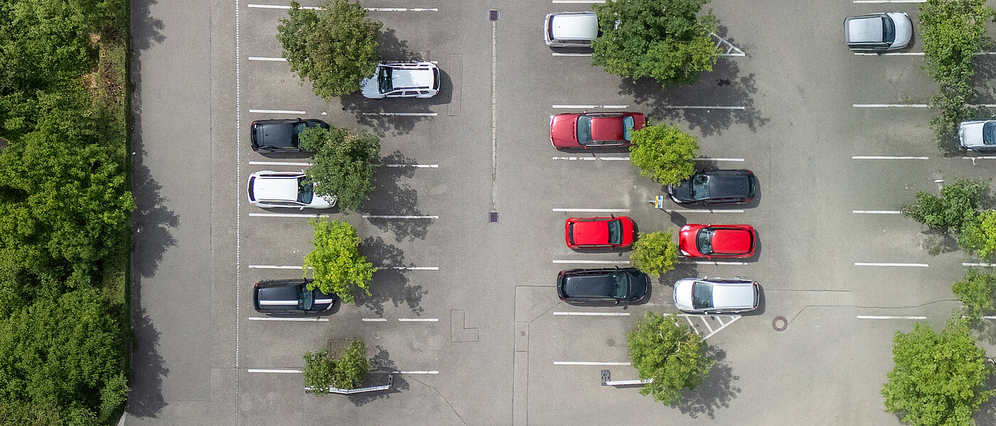 Luftbildaufnahme eines Parkplatzes mit oben und verschiedenen Autos.