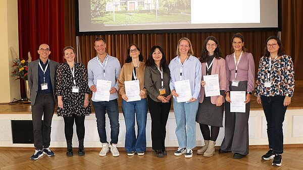 Das Gruppenbild zeigt neun Männer und Frauen bei der Preisverleihung des BFLK-Landespflegepreises 2025 im Festsaal des ZfP Reichenau.