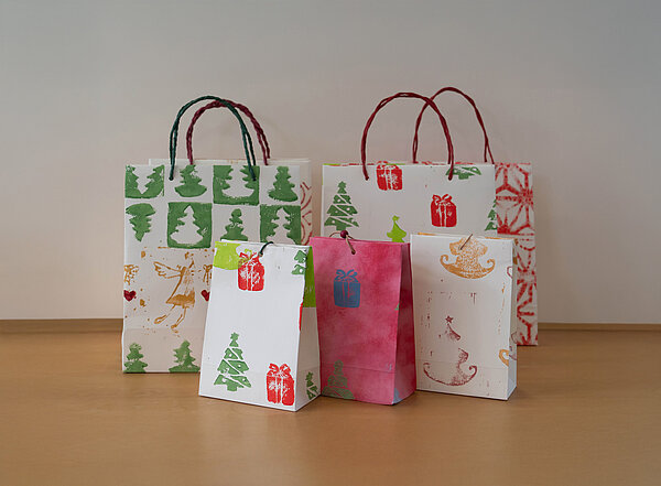 Bunt bedruckte, weihnachtliche Papiertüten in verschiedenen Größen.