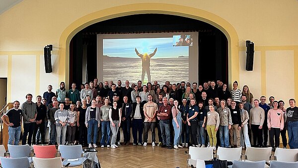 Rund 80 Menschen haben sich für ein Gruppenfoto an der Bühne des Festsaals des ZfP Reichenau aufgestellt.