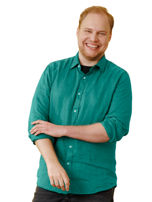 Ein junger Mann, stehend, mit grünem Hemd.