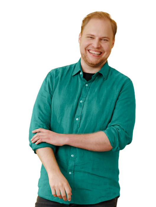 Ein junger Mann, stehend, mit grünem Hemd.
