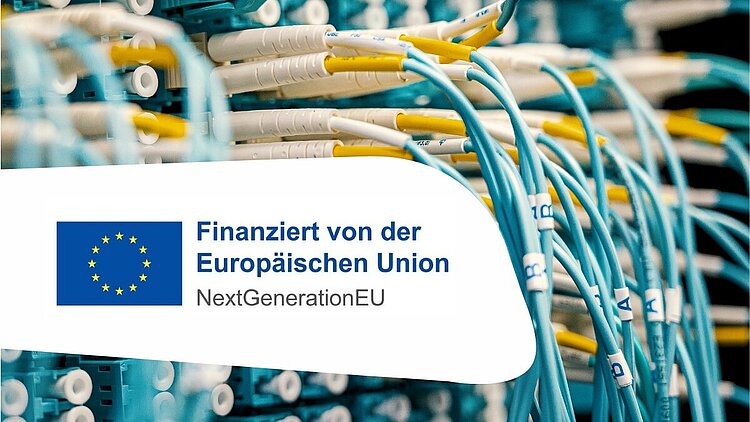Im Hintergrund sind viele blaue Kabel, weiße und gelbe Stecker zu sehen und im Vordergrund das Logo der EU.