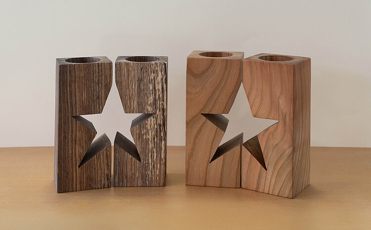 Kerzenständer für Teelichter aus Holz mit einer Sternform in der Mitte.