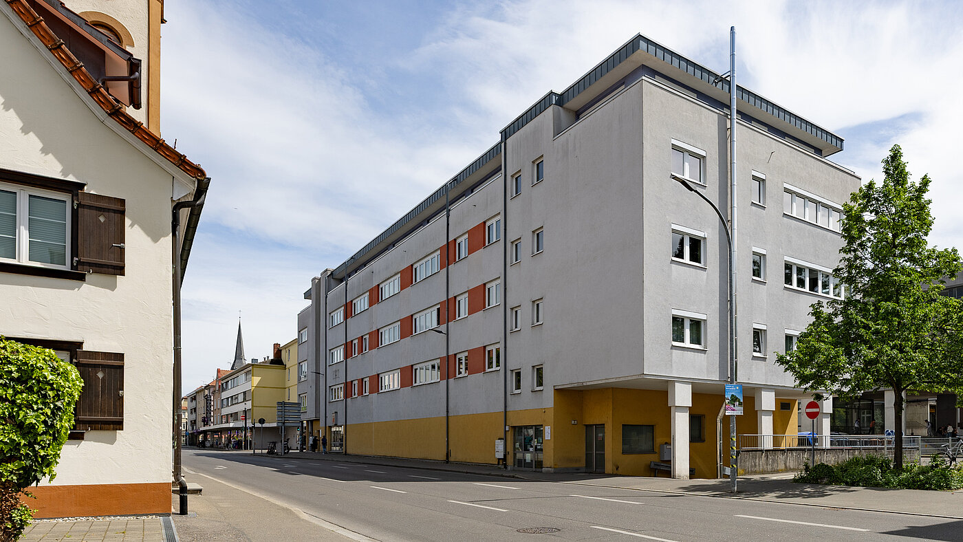 Mehrstöckiges Gebäude an einer Straße in einem Ort.