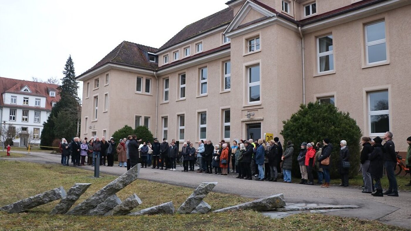 Im Vordergrund sind die Granitstelen des Mahnmals zu sehen, im Hintergrund die rund 80 Teilnehmenden.